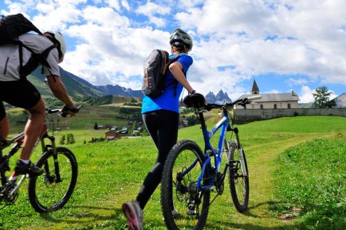 une femme debout à côté de deux vélos sur un champ dans l'établissement Résidence Goélia Le Relais des Pistes, à Albiez-le-Vieux