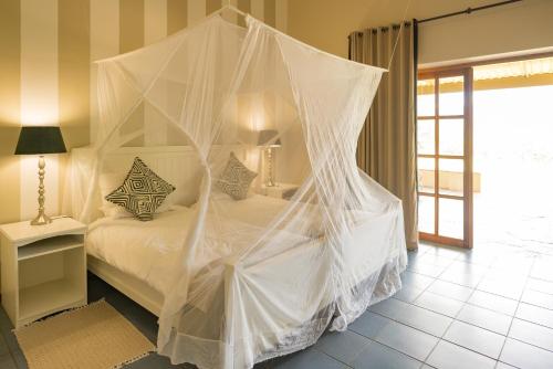a bedroom with a bed covered in nets at Ghaub Nature Reserve & Farm - ONE Namibia in Groutfontein