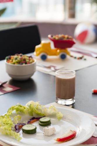 a plate of food with cucumbers and a salad on a table at Leonardo Club Eilat - All Inclusive in Eilat