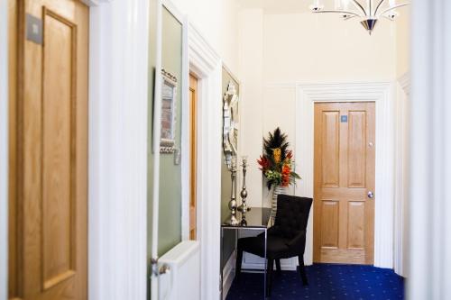 a hallway with a desk and a chair and a door at Washington House Hotel in Bournemouth