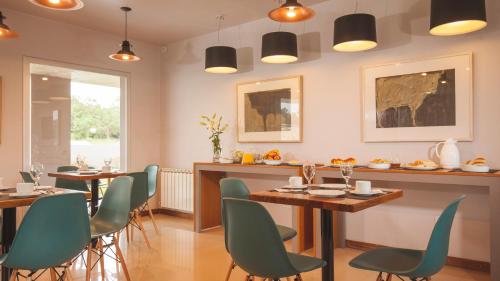 a dining room with two tables and green chairs at Amalinas Hotel in San Lorenzo