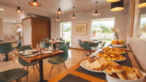 una sala de desayunos con pan y bollería en una mesa en Amalinas Hotel en San Lorenzo