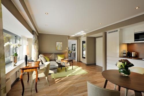 a living room with a couch and a table at Kastens Hotel Luisenhof in Hannover