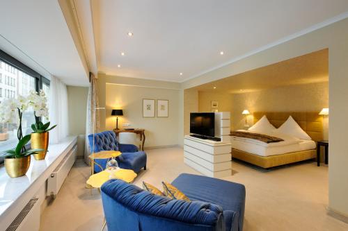 a hotel room with a bed and a tv at Kastens Hotel Luisenhof in Hannover