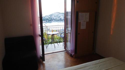 a room with a door open to a balcony with a table at Pansion Panorama Dubrovnik in Dubrovnik