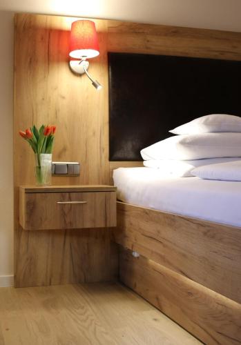 a bedroom with a bed with a lamp on a night stand at Hotel Sonnenhügel in Bad Bevensen