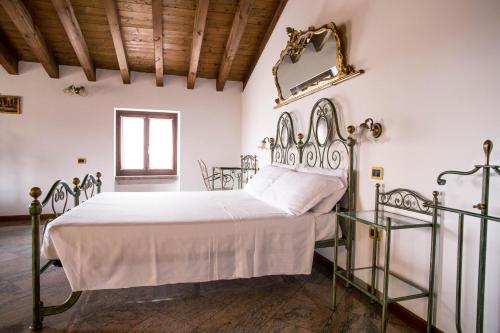 1 dormitorio con 1 cama blanca con marco metálico en Hotel e Locanda La Bastia, en Valeggio sul Mincio