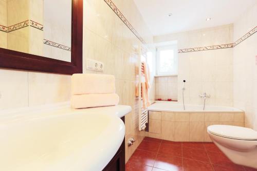 a bathroom with a toilet and a tub and a sink at Sattelbogener Hof in Traitsching