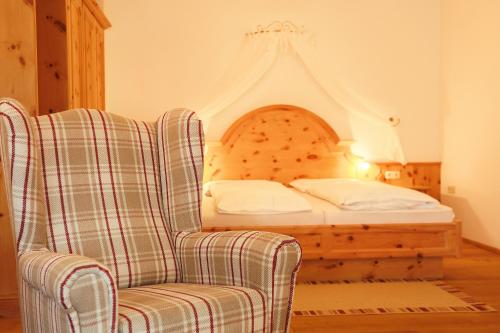 a bedroom with a bed and a chair and a bed at Sattelbogener Hof in Traitsching
