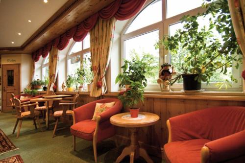 a restaurant with chairs and a table and windows at Sattelbogener Hof in Traitsching