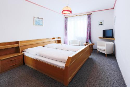 a hotel room with a bed and a television at Sattelbogener Hof in Traitsching