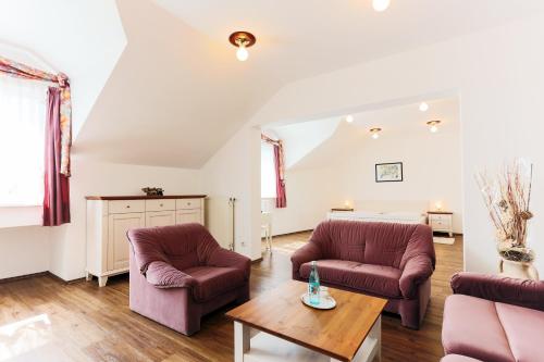 a living room with two chairs and a table at Sattelbogener Hof in Traitsching