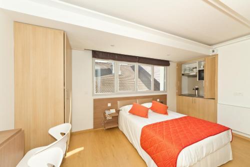 a bedroom with a large bed with orange pillows at Villa Thermae Thonon-Les-Bains in Thonon-les-Bains