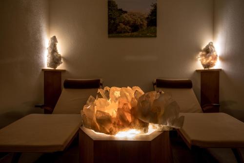 a fire pit in a waiting room with two chairs at Hotel-Gasthof Mauthäusl in Weißbach