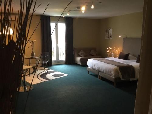 a bedroom with a bed and a couch and a window at Le Renaissance in Mont-de-Marsan