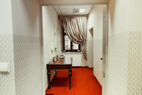 a hallway with a wooden table and a window at Rynek 6 retro pub & hostel in Radom