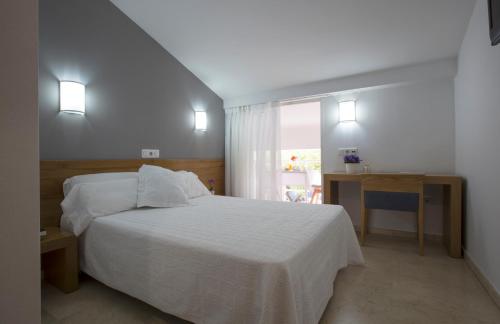 a bedroom with a white bed and a window at Hotel Casbah in El Puig