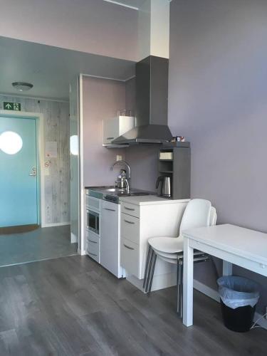 a kitchen with a table and a white counter top at Værlandet Havhotell in Hamna