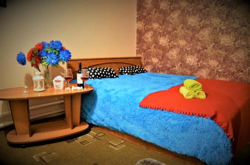 SalavatにあるВ центреのベッドルーム1室(ベッド1台、テーブル、青い毛布付)