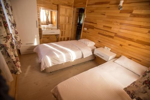 キラリにあるCirali Vi̇llasの木製の壁にベッド2台が備わるベッドルーム1室