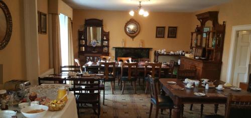 a dining room with tables and chairs and a fireplace at Meath Arms Country Inn in Aughrim
