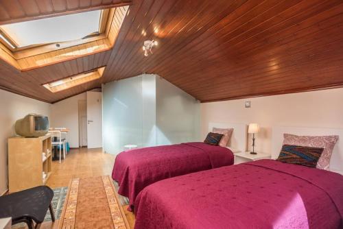 Un dormitorio con dos camas y techo de madera. en Lisbon Belém Guesthouse, en Lisboa