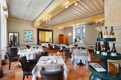 a restaurant with white tables and chairs and bottles of wine at Château de Pizay in Belleville-sur-Saône