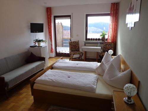 a living room with two beds and a couch at Gasthof - Pension Schamberger in Neukirchen beim Heiligen Blut