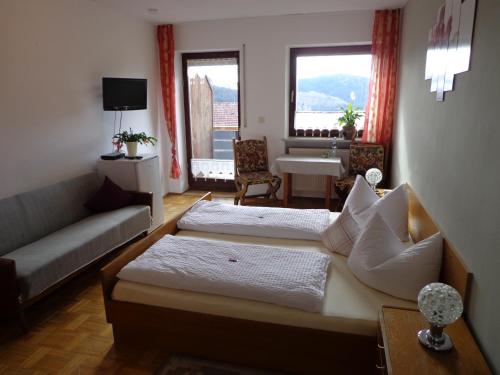 a living room with two beds and a couch at Pension Schamberger in Neukirchen beim Heiligen Blut