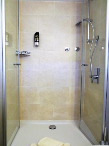 a shower with a glass door and a walk in shower at Hotel Alp Inn - Chiemgaukarte inclusive in Ruhpolding