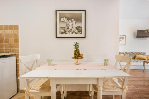 a dining room with a white table and chairs at Marinero Apartments in Budva