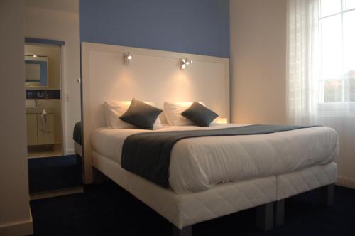 a bedroom with a large bed with white sheets and pillows at La Pergola d'Arcachon in Arcachon