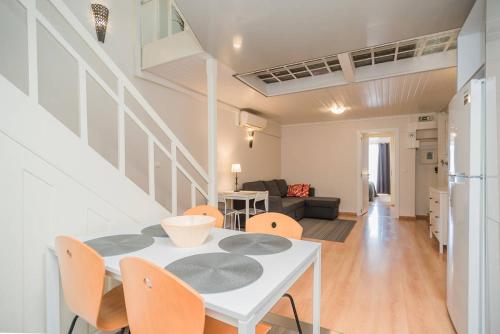 a dining room and living room with a white table and chairs at Lisbon Belém Guesthouse in Lisbon