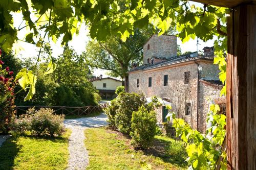 a view of a garden with an old building at Monsignor Della Casa Country Resort & Spa in Borgo San Lorenzo