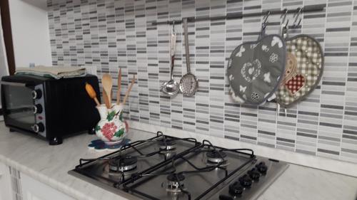 a stove top in a kitchen with plates and utensils at Little house in Alghero