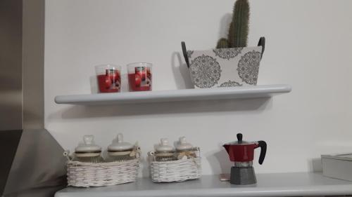 a kitchen counter with two baskets and a cactus on a shelf at Little house in Alghero