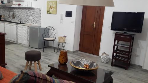 a living room with a couch and a tv at Little house in Alghero