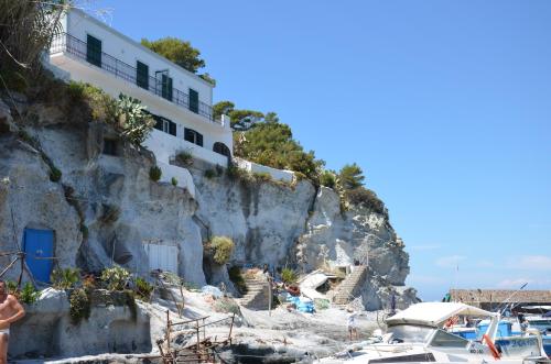 ein Haus auf einer Klippe neben Booten am Strand in der Unterkunft Maridea - Donatino a Mare in Ponza
