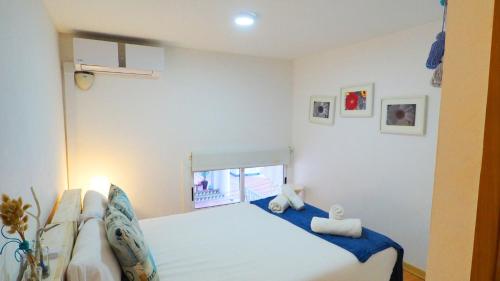 シッチェスにあるCalafat Apartment by Hello Homes Sitgesのベッドルーム1室(窓、白いベッド1台付)