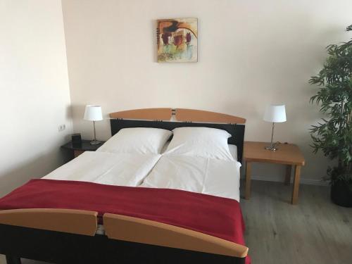 Bett in einem Zimmer mit 2 Tischen und 2 Lampen in der Unterkunft Steiner Strandappartements Appartement 308 Süd- Landseite in Stein