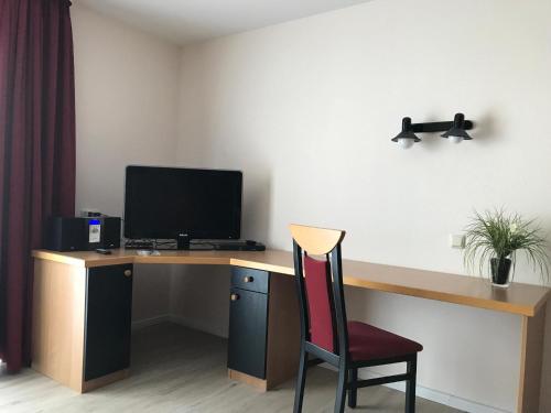 a room with a desk with a computer and a chair at Steiner Strandappartements Appartement 202 Seeseite in Stein