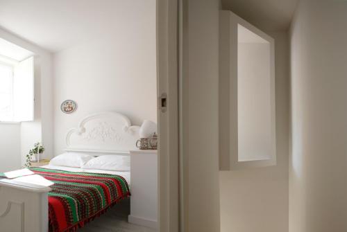a white bedroom with a bed with a red blanket at Casa de Baixo in Coimbra