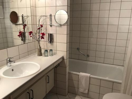 a white bathroom with a sink and a bath tub at Steiner Strandappartements Appartement 205 Seeseite in Stein