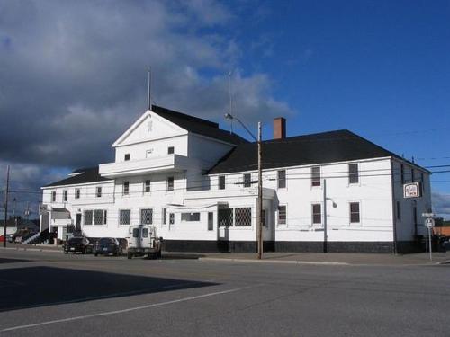 a large white building with a black roof at Lakeview Hotel in Wawa
