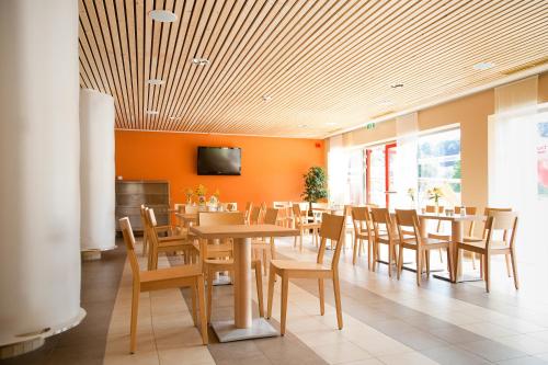 a dining room with tables and chairs and a tv at JUFA Hotel Leibnitz in Leibnitz
