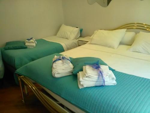 two beds in a room with towels on them at Dimora Tafuri in Salerno