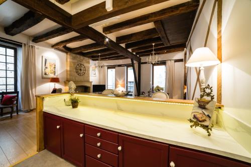 eine Küche mit einer großen Theke und einem großen Spiegel in der Unterkunft Duplex Cité Médiévale Sarlat in Sarlat-la-Canéda