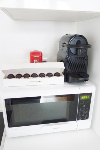 a microwave with a toaster oven on top of it at Avenue de La Paix - L'Exclusif in Strasbourg