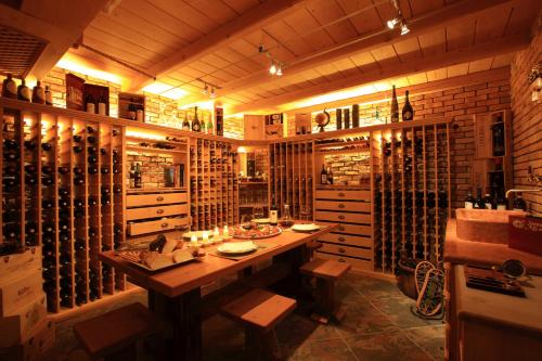 a wine cellar with a wooden table and some wine bottles at Dolce Avita Hotel Spa & Resort in Andalo