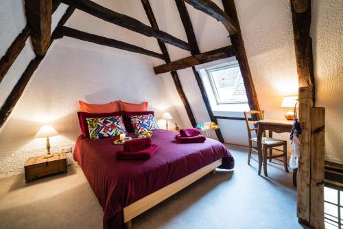ein Schlafzimmer mit einem großen Bett mit roter Bettwäsche in der Unterkunft Duplex Cité Médiévale Sarlat in Sarlat-la-Canéda